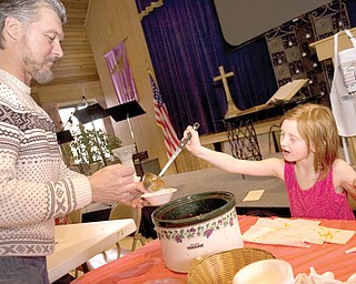 Ilisabeth Hernan, 6, of Poland fills a bowl with a traditional chili Sunday for Tim Hardy of Youngtown during the 4th Annual Sue Hernan Chili Cook-Off at Boardman United Methodist Church. Ilisabeth is a granddaughter
of Sue Hernan, who died in a drowning accident.