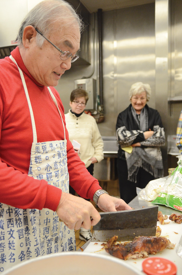 Dr. Y.T. Chiu uses a cleaver to chop up a roasted duck while Wendy Owens, left, and Beverly Italiano watch.
He and his wife, Marilyn, presented “From the Garden: Chinese New Year” at Fellows Riverside Gardens.