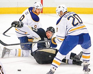 Penguins captain Sidney Crosby (87) reaches for the puck after colliding with Sabres defender Steve Ott (9) behind teammate Henrik Tallinder (20) in Monday’s game in Pittsburgh. The Pens won, 3-0.