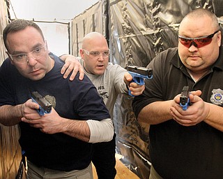 Bob Richardson, center, works with Sgt. Don Coppola of the Lowellville Police Department, left, and patrolman Patrick Campbell of the Struthers Police Department during an eight-hour law enforcement training session at Lowellville City Hall on Tuesday. Richardson, a law enforcement training officer with the Ohio Peace Officer Training Academy, was one of two instructors at the session, which was intended to help officers more safely and efficiently conduct building searches.