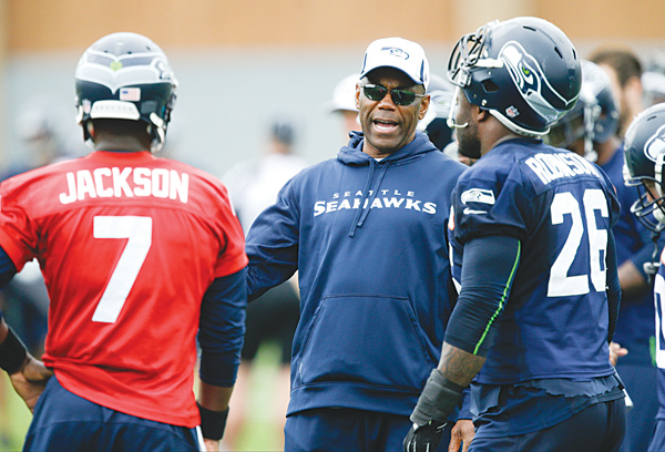 Seattle running backs coach Sherman Smith, center, talks with Seahawks backup quarterback Tarvaris Jackson (7) and fullback Michael Robinson (26). Before he was a coach with his second Super Bowl team … before he spent eight years as an NFL player … before he won three Mid-American Conference titles as Miami’s (Ohio) first black quarterback, Smith was a Youngstown teen who couldn’t see past the city limits.