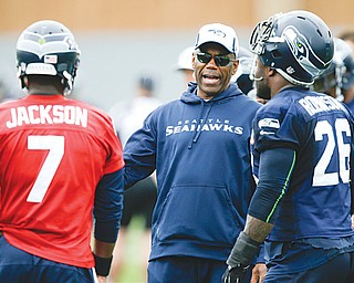 Seattle running backs coach Sherman Smith, center, talks with Seahawks backup quarterback Tarvaris Jackson (7) and fullback Michael Robinson (26). Before he was a coach with his second Super Bowl team … before he spent eight years as an NFL player … before he won three Mid-American Conference titles as Miami’s (Ohio) first black quarterback, Smith was a Youngstown teen who couldn’t see past the city limits.
