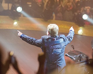 Elton John points up at fans in the upper level of the arena after playing his second song, “Bennie and the Jets,” at the Covelli Centre concert. He was wearing a bedazzled blue jacket bearing the title of one of his songs, “Madman Across the Water.”