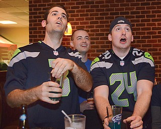 Seahawk fans (L-R) Philip Cogar, Jacob Short, and Will Ferrand react to a play during the first quarter of the Super Bowl. They are among a small crowd gathered at Inner Circle Pizza in Canfield to watch the game.