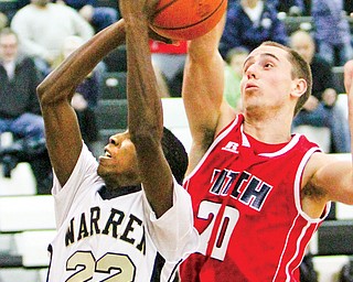 Fitch’s Alex DiFrancesco(20) defends Warren Harding’s King Garner (22) during Tuesday’s game in Warren. Harding defeated Fitch 71-44.