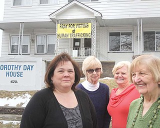A banner at the Dorothy Day House of Hospitality, 620 Belmont Ave., Youngstown, promotes prayer for victims of human trafficking. A vigil will start at midnight Friday and continue through Saturday to raise awareness about the issue. Promoters of the event are, from left, Vicki Vicars, Mary Grace Manning, Valerie Seaborn and Ceil Schlosser.