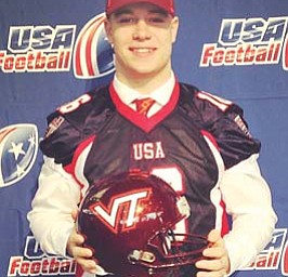 Ursuline quarterback Chris Durkin holds up a Virginia Tech helmet after signing his letter of intent to play college
football for the Hokies during a ceremony on Wednesday at AT&T Stadium in Arlington, Texas.