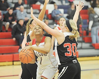 Fitch’s Aaliyah Sadler goes to the basket against Struthers defenders Ashley Kane (30) and Halle Smrek (32) during the second quarter of Thursday’s game at Fitch High School in Austintown. The Falcons downed the Wildcats, 52-45