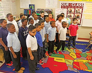 Laurie McEwan’s fourth-grade class, above, performs the school song Monday. Each class will sing the song, and a panel of judges will narrow down the competition until a winner is identified.