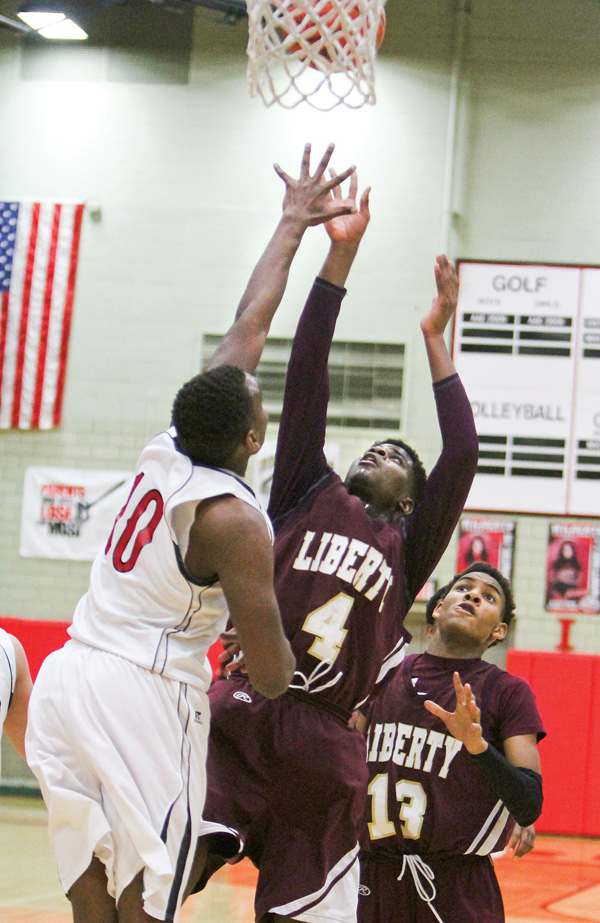 Liberty’s Asim Pleas (4) puts up a jump shot while being defended by Struthers’ Tameko Holness (10) during the third quarter Tuesday night at the Struthers Field House. Pleas made the bucket to reach 1,000 points in his high school career, and scored 24 points in Liberty’s 66-63 victory.