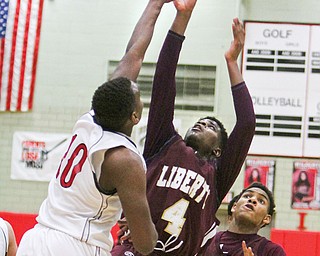 Liberty’s Asim Pleas (4) puts up a jump shot while being defended by Struthers’ Tameko Holness (10) during the third quarter Tuesday night at the Struthers Field House. Pleas made the bucket to reach 1,000 points in his high school career, and scored 24 points in Liberty’s 66-63 victory.