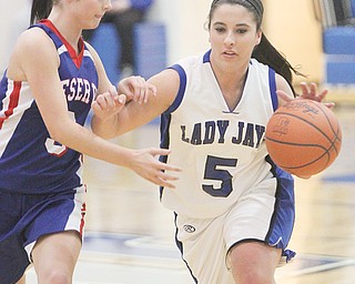Jackson-Milton’s Gabby Tharp drives up the court past Western Reserve defender Lauren Falasca during the first half other their game Wednesday at Jackson Milton High School in North Jackson. The BlueJays downed the Blue Devils, 64-62, in overtime.