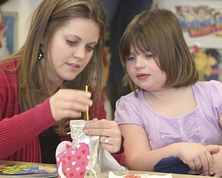 William D.Lewis The Vindicator Austintown Elem school kindergarten teacher Jen Kalouris helps student Emily with a Valentines craft project a Valentines day party at the school 2-13.