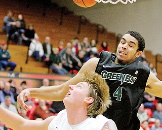 Youngstown State’s Bobby Hain and Green Bay’s Jordan Fouse go for a rebound during their Horizon League
game Thursday at YSU’s Beeghly Center. The Penguins were routed by the Phoenix, 71-40.