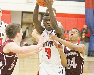 Fitch’s Jessie Driver makes his way to the hoop past Boardman’s Alex Duda (5) and Brandon Rozzi (24) during their game Tuesday at Fitch High School in Austintown. The Falcons downed the Spartans, 69-59.