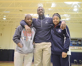 Warren JFK basketball player James Burney Jr., center, poses with his 13-year-old brother Quintin Burney, left, and sister Taejah Burney, 15, in the gymnasium at Warren JFK High School on Tuesday. Basketball has become an outlet for grief for the siblings after the unexpected death of their mother Timika Burney, last month.