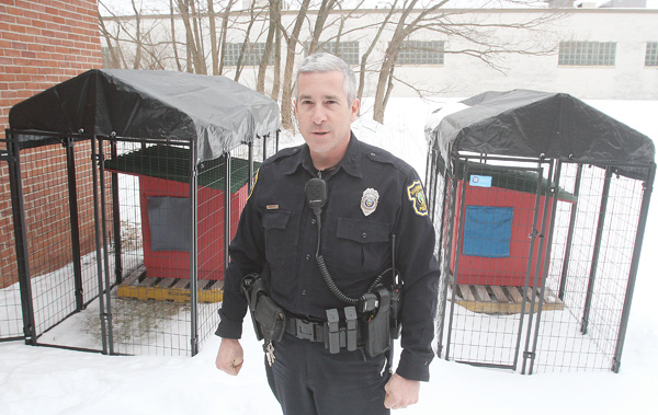 Boardman Police Department officer Jack Neapolitan stands near two new kennels the department will use to temporarily house dogs with no place to go.