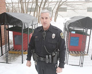 Boardman Police Department officer Jack Neapolitan stands near two new kennels the department will use to temporarily house dogs with no place to go.
