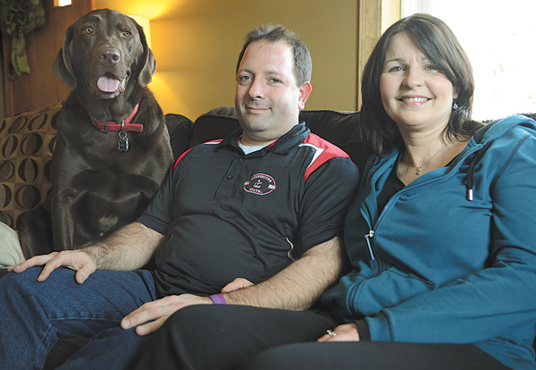 Missy Ginnetti, right, poses with husband Patrick Ginnetti and dog Max in their Struthers home. Missy has been fighting Hodgkin lymphoma on and off since being diagnosed in June 2010, and soon may undergo an allogeneic stem-cell transplant.
