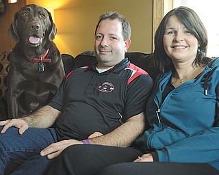 Missy Ginnetti, right, poses with husband Patrick Ginnetti and dog Max in their Struthers home. Missy has been fighting Hodgkin lymphoma on and off since being diagnosed in June 2010, and soon may undergo an allogeneic stem-cell transplant.