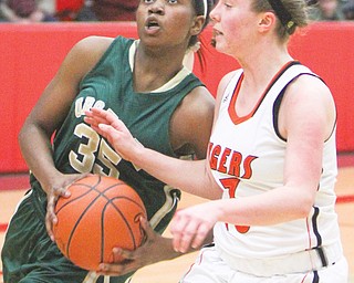 Ursuline’s Tanaya Beacham drives around Mary Ritter of Springfield on Thursday at the Division III district 
semifinal at the Struthers Fieldhouse. Beachum posted a game-high 27 points for the Irish, who downed the Tigers, 61-44. Ursuline faces South Range in the title game on Saturday.