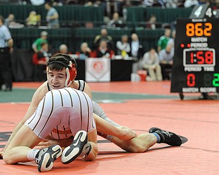 COLUMBUS, OHIO - FEBRUARY 28, 2014: Korey Frost of Canfield rides the back of Dustin Warner of Uhrichsville Claymont during their 120lb championship bracket bout during the 2014 division 2 state wrestling tournament at Schottenstein Center.