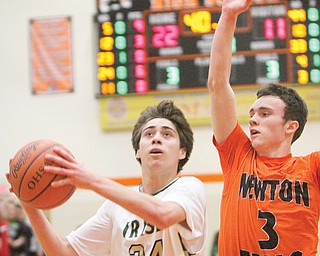 Ursuline’s Greg Parella goes to the hoop past Newton Falls defender Jaden Walton during their Division III
district semifinal Tuesday at Howland High School. The Irish routed the Tigers, 74-44.
