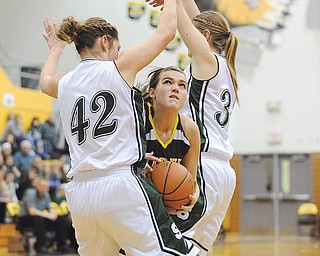 Starla Sharp of South Range drives between Smithville defenders Natalie Indernuhle (42) and Macy McKelley
(33) on her way to the basket during during a Division III regional semifinal at Cuyahoga Falls High School. The
Smithies were too much for the Raiders, who fell 44-16.
