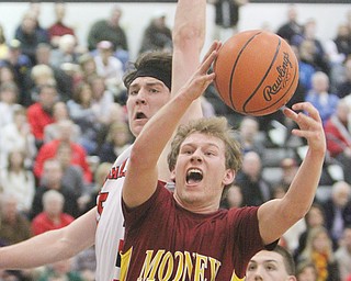 Cardinal Mooney’s Joey Kleeh shoots past Canfield’s Jarret Vrabel during their Division II district semifinal Thursday at Warren G. Harding High School. Mooney held off Canfield, 60-50, to advance to Saturday’s final.