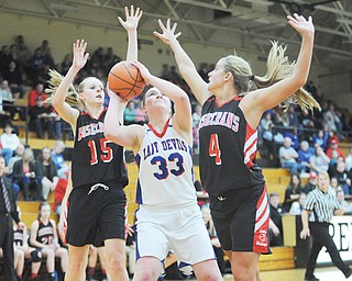 Western Reserve’s Aleah Hughes is hemmed in by Bishop Rosecrans defenders Kloie Johnson (4) and Molly Nash (15) during the first half of their Division IV regional semifinal Thursday at Massillon Perry High School. The Blue Devils’ season came to an end in a 67-31 loss to the Bishops.