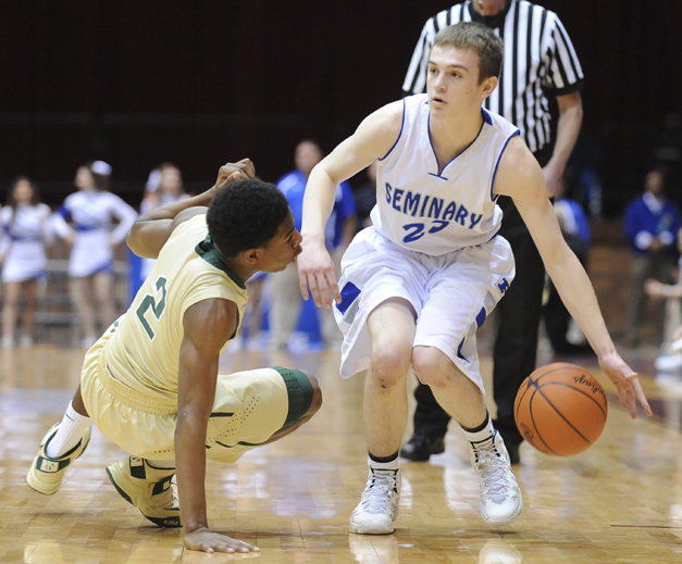 CANTON, OHIO - MARCH 15, 2014: Jared Burkert #23 of Poland looks to pass the ball after tripping up Johnnie Robinson #2 of SVSM during the first half of the regional final game Saturday afternoon at the Canton Civic Center.