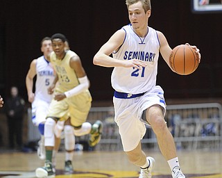 CANTON, OHIO - MARCH 15, 2014: Kyle Dixon #21 of Poland dribbles the ball to the basket ahead of VJ King of SVSM and teammate Jacob Wolfe #5 during the first half of the regional final game Saturday afternoon at the Canton Civic Center.