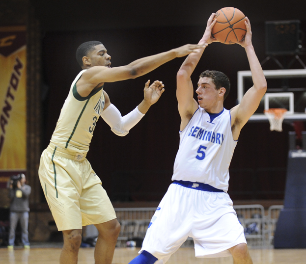 CANTON, OHIO - MARCH 15, 2014: Jacob Wolfe #5 of Poland looks to pass the ball to a teammate while being pressured by Jalen Hudson #3 of SVSM during the first half of the regional final game Saturday afternoon at the Canton Civic Center.