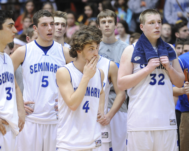 CANTON, OHIO - MARCH 15, 2014: Jacob Wolfe #5, Steven Andrews #4, and # Danny Black #32 of Poland react while watching players for SVSM celebrate on the court after the regional final game Saturday afternoon at the Canton Civic Center. Poland #33 George Chammas pictured.