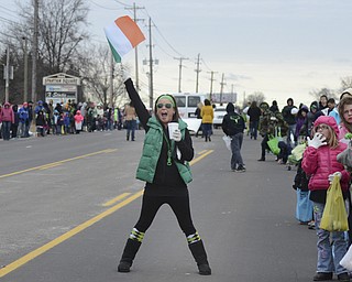 Katie Rickman | The Vindicator.Terra Koontz, 25, of Youngstown waves her flag and cheers as the St. Patrick's Day parade passes by Sunday afternoon.