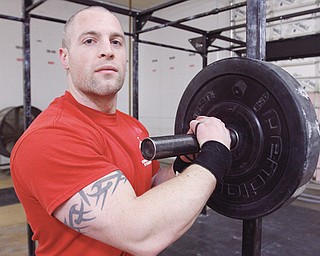 Strongman competitor Richard Stout of Niles works out Tuesday with the steel log, top, and on weights, above, at Team BSS in Boardman. Stout recently competed for Team USA at the Strongman World Championship at the Arnold Classic Sports Festival in Columbus in the lightweight class (under 185 pounds), finishing fourth overall.