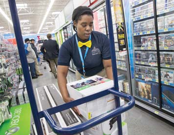 Tracey Anderson restocks Xbox consoles on opening day of a new Wal-Mart in Washington. Wal-Mart plans to expand its video-game trade-in program to its stores, offering store credit for other video games and other products.