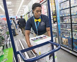 Tracey Anderson restocks Xbox consoles on opening day of a new Wal-Mart in Washington. Wal-Mart plans to expand its video-game trade-in program to its stores, offering store credit for other video games and other products.