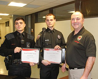 Youngstown police officer Tim Edwards, left, Goshen police officer Anthony Pilolli and Ed Villone, commander of the Youngstown State University Peace Officer Training Academy, stand Wednesday with awards Edwards and Pilolli won for saving the lives of a baby and a person at a gym, respectively, in January. Both are graduates of the
academy.