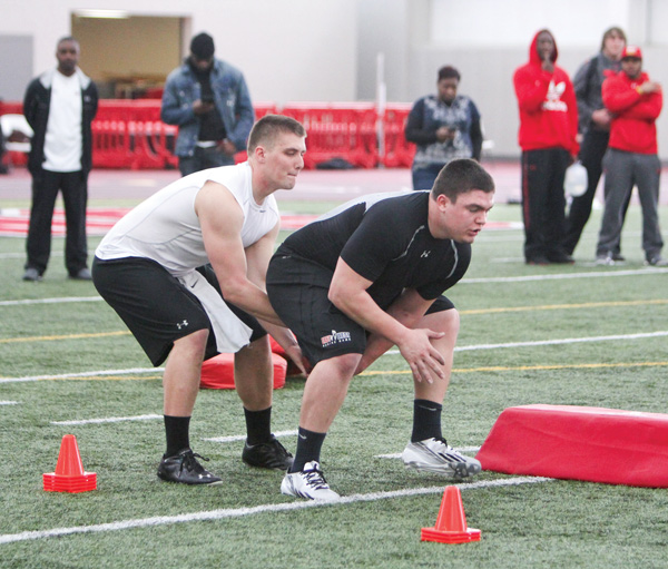 Former Youngstown State football players Kurt Hess, left, and Chris Elkins run through snapping drills Wednesday during Pro Day at YSU’s Watson and Tressel Training Site. Hess and Elkins were among six ex-Penguins who showcased their talents for NFL scouts from the Browns, Steelers, 49ers, Giants and Chargers.