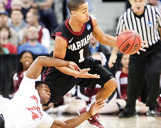 Harvard's Siyani Chambers (1) and Cincinnati's Ge’Lawn Guyn (14) fight for a loose ball during the second half
of a second-round game in the NCAA basketball tournament in Spokane, Wash., on Thursday.