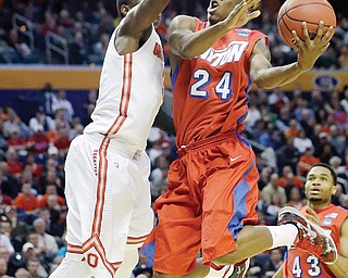 Dayton’s Jordan Sibert (24) drives past Ohio State’s Shannon Scott during the second half of a second-round
game in the NCAA basketball tournament in Buffalo, N.Y., on Thursday. Dayton won 60-59.