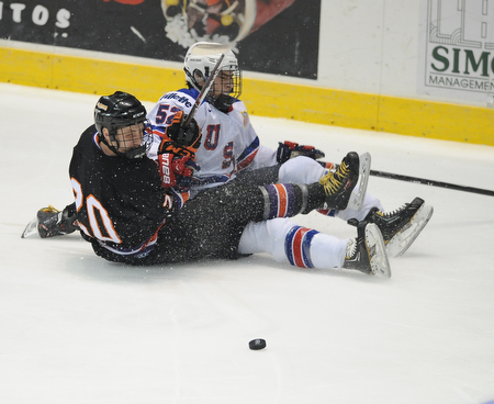 YOUNGSTOWN, OHIO - MARCH 21, 2014: Carson Gicewicz #20 of the Phantoms and Brody Stevens #52 of Team USA slide on the ground after colliding while trying to play the puck during the 2nd period of Friday morning against Team USA at the Covelli Centre. The Phantoms won 7-3.