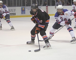 Trey Bradley (10) of the Youngstown Phantoms skates the puck down the ice while being defended by Team USA's Charles McAvoy (41) during the first period of Friday morning's matchupat the Covelli Centre.  Dustin Livesay  |  The Vindicator  3/21/14  Covelli Centre