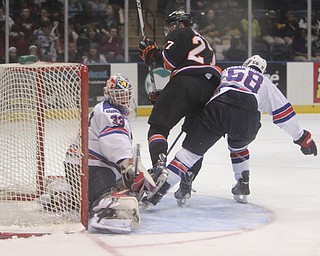 Luke Stork (27) of the Youngstown Phantoms flips in a goal past Team USA goalie Luke Opilka (33) and moved past the defense by Casey Fitzgerald (58) during the first period of Friday morning's matchupat the Covelli Centre.  Dustin Livesay  |  The Vindicator  3/21/14  Covelli Centre