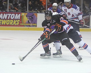Connor Moore (28) of the Youngstown Phantoms skates the puck toward the goal while being defended by Team USA's Charles McAvoy (41) during the first period of Friday morning's matchupat the Covelli Centre.  Dustin Livesay  |  The Vindicator  3/21/14  Covelli Centre