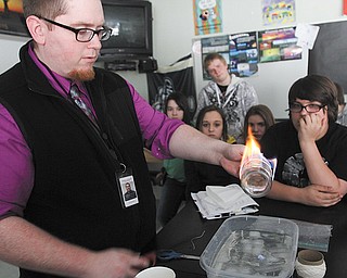 Scott Stoddart, a seventh-grade science teacher at Struthers Middle School, performs an experiment meant to illustrate why elements behave the way they do. Beginning this fall, Struthers schools will incorporate science, technology, engineering and mathematics into all levels of education.