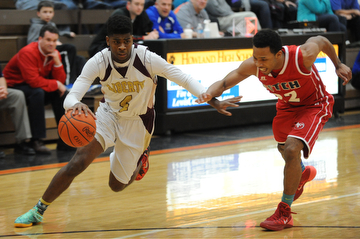 HOWLAND, OHIO - MARCH 25, 2014: Asim Pleas #4 of Liberty dribbles to the basket inside of Quincy Higgins #22 of Fitch during Tuesday nights Frank Bubba Classic boys basketball all-star game at Howland High School.