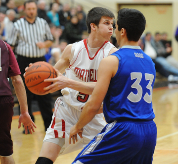 HOWLAND, OHIO - MARCH 25, 2014: Wyatt Ford #5 of Mathews looks to pass the ball while being guarded under the basket by George Chammas #33 of Poland during Tuesday nights Frank Bubba Classic boys basketball all-star game at Howland High School.