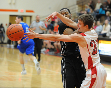 HOWLAND, OHIO - MARCH 25, 2014: Brandon Bates #21 of Badger reaches for the ball after poking it out of the control of Terrell McClain #20 of East during Tuesday nights Frank Bubba Classic boys basketball all-star game at Howland High School.